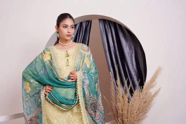 Young woman in a lemon yellow chikankari suit draped with a teal printed dupatta, in front of a curtained arch