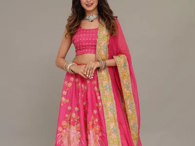 Woman in a fuchsia pink floral lehenga with a gold-bordered dupatta, in a studio