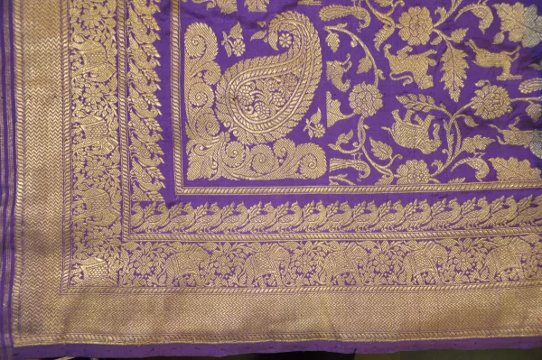 Purple Banarasi saree pallu with gold zari paisley motifs, laid flat