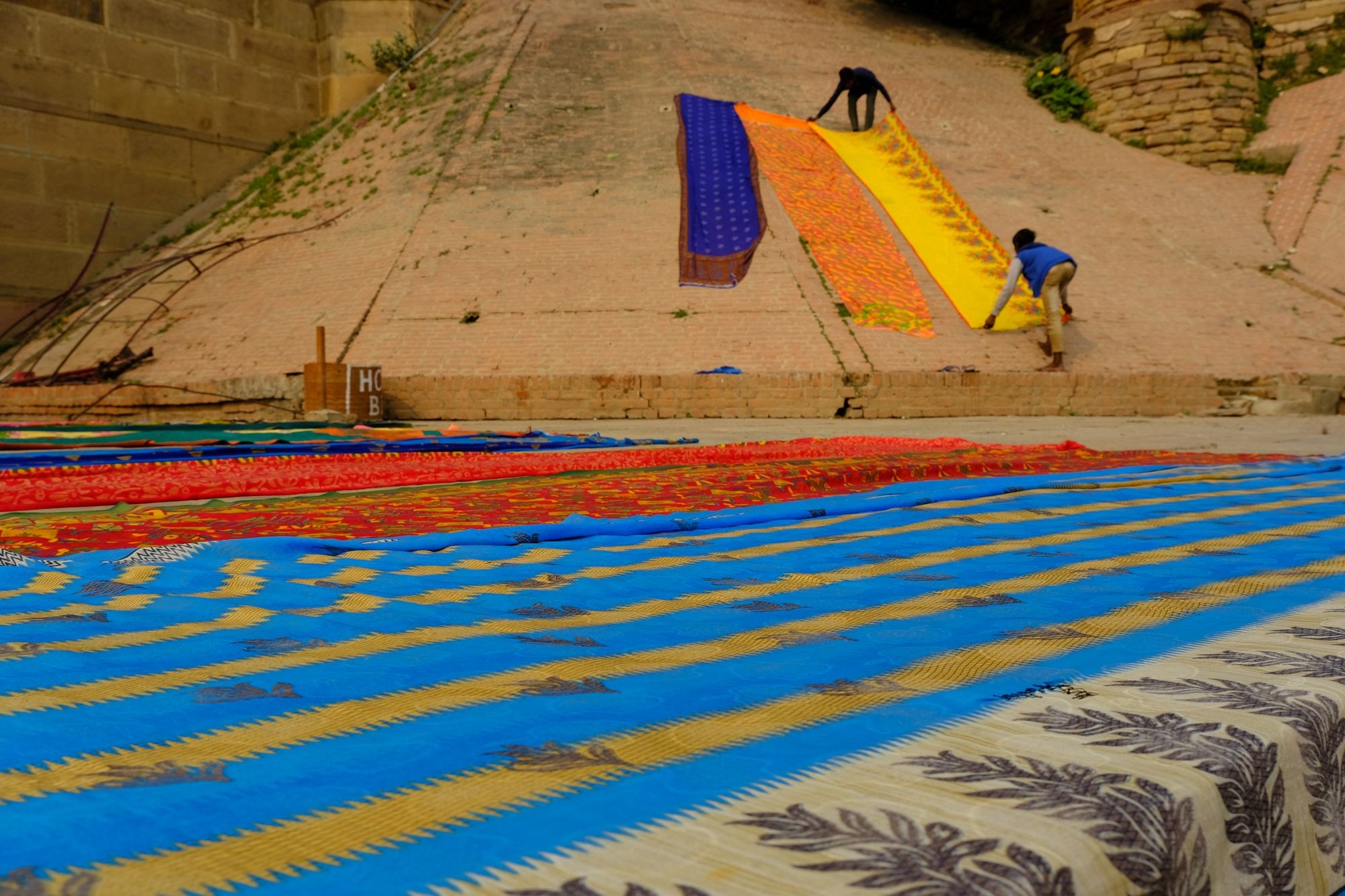 Colourful sarees spread out to dry on river ghat steps