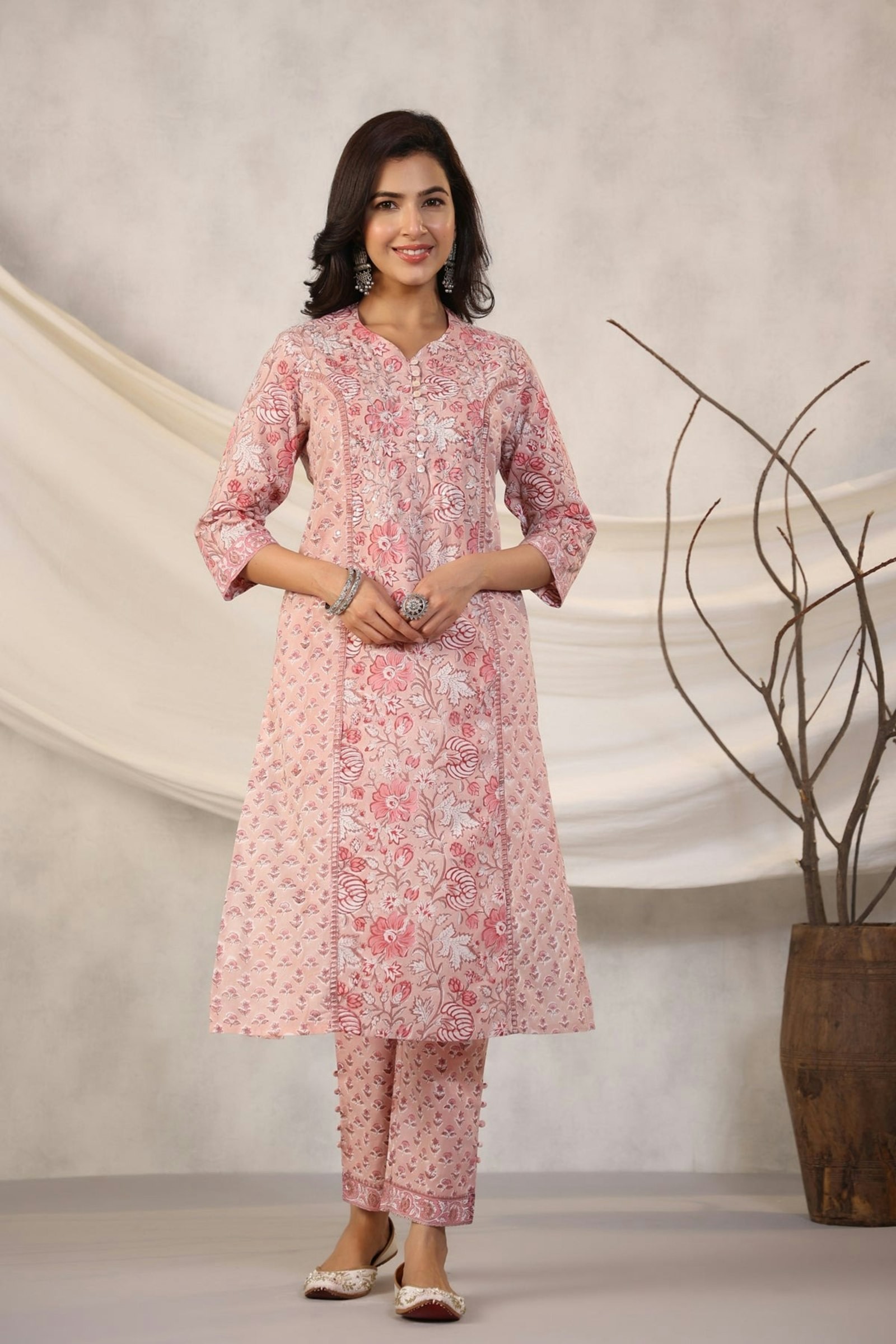 Woman in a pink floral block-printed A-line kurta with matching pants