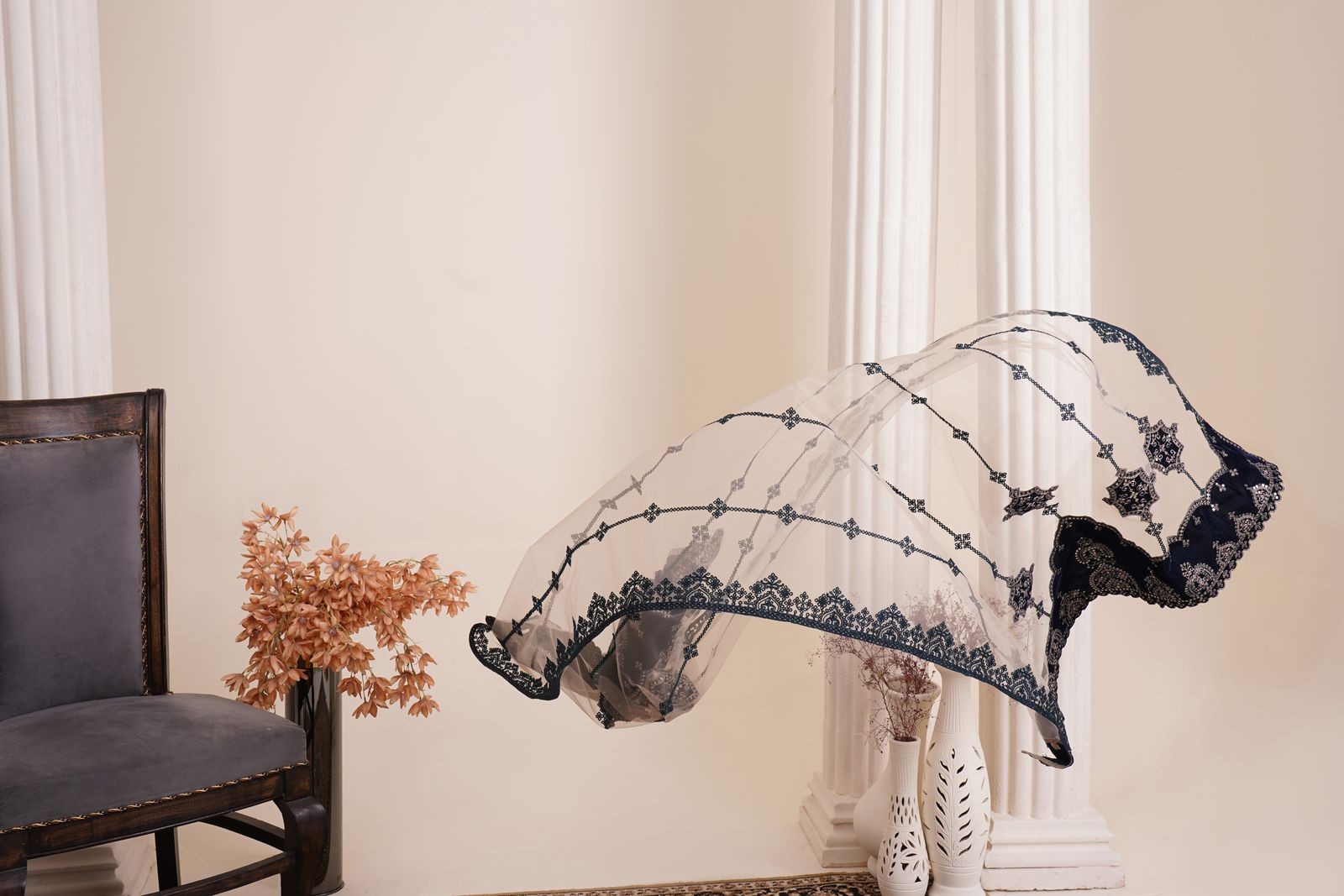 White organza dupatta with black embroidery, floating against a plain background