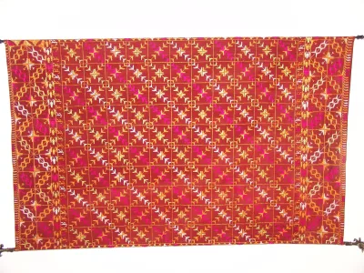 Red and gold phulkari embroidered dupatta laid flat to show the floral darn work